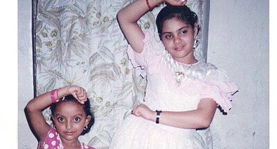 Zwei tanzende Kinder in Kleidern, das linke Kind zeigt Parvathi Ramanathan.